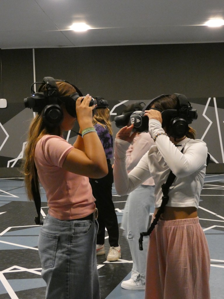 Zwei Mädchen stellen ihre VR-Headsets ein